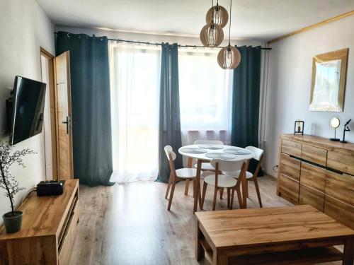 een woonkamer met een tafel en stoelen en een keuken bij Apartament Wałbrzych / Piaskowa Góra in Wałbrzych