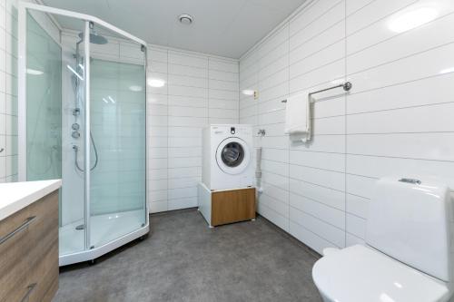 a bathroom with a washing machine and a shower at Langfoss in Etnesjøen