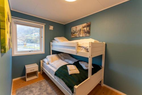 a bedroom with two bunk beds and a window at Langfoss in Etnesjøen