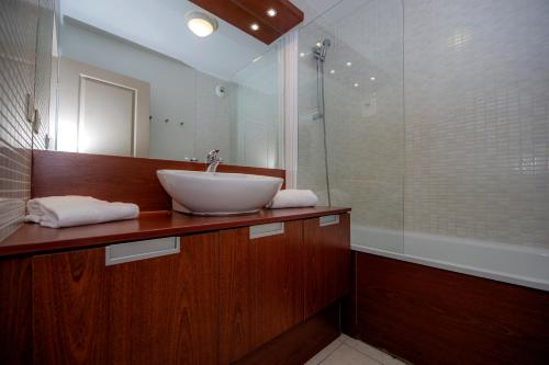 La salle de bains est pourvue d'un lavabo et d'une douche. dans l'établissement Goélia Mandelieu Riviera Resort, à Mandelieu-la-Napoule