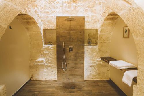 a bathroom with a shower in a stone wall at TRULIVO in Monopoli