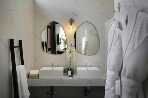 a bathroom with two sinks and two mirrors at Villa LOULA in Marrakesh