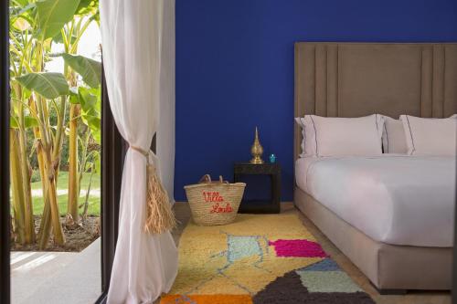 a bedroom with a white bed and a window at Villa LOULA in Marrakesh