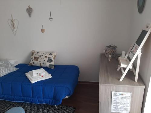 a small bedroom with a blue bed and a chair at CA' VIRASOLELH in Macra