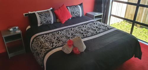 a bedroom with a bed with two stuffed animals on it at De Vine Martinborough 14 Cologne Street in Martinborough 