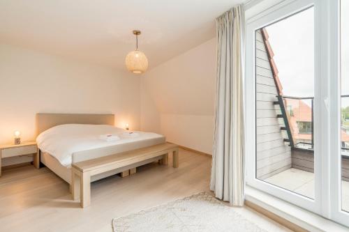 a bedroom with a bed and a large window at Renewed comfort duplex w 2 terraces nearby Marina in Nieuwpoort