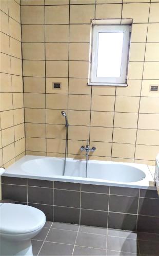 a bathroom with a tub and a toilet at Grey Haven Luxury Villa in Stérnai