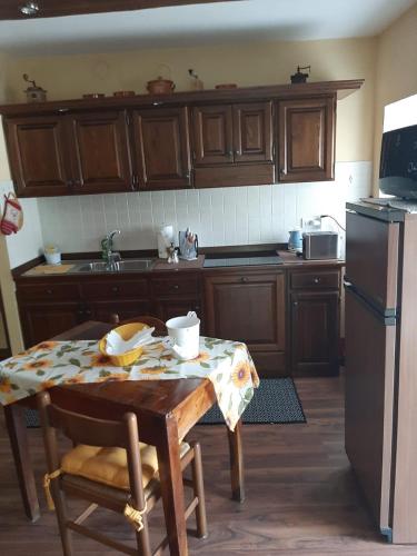 a kitchen with a table and a refrigerator at CA' VIRASOLELH in Macra