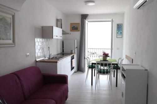 a kitchen with a couch and a table in a room at Casa Maadry in Ischia