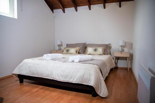 a bedroom with a bed with two pillows and two tables at Grey Haven Luxury Villa in Stérnai