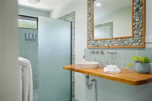a bathroom with a sink and a mirror at Airlie Guest House in Airlie Beach