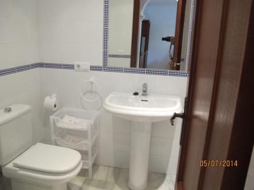 a bathroom with a sink and a toilet and a mirror at URBANIZACION EL ATARDECER in Novo Sancti Petri