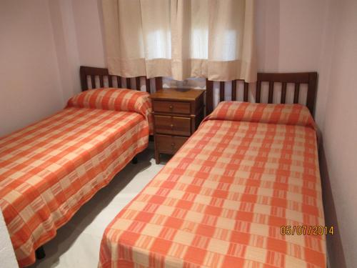 - deux lits assis l'un à côté de l'autre dans une pièce dans l'établissement URBANIZACION EL ATARDECER, à Novo Sancti Petri