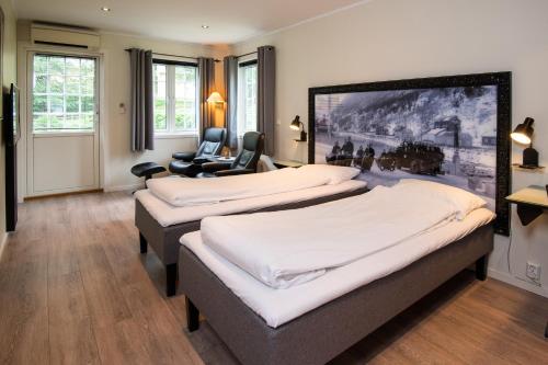 a room with three beds and a chair at Rjukan Hytteby in Rjukan