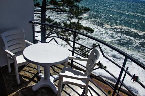 a white table and chairs on a balcony with the ocean at Hotel Medusa in K'obulet'i