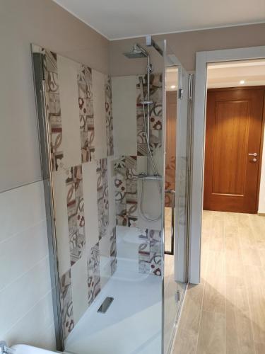 a bathroom with a shower with a glass door at B&B La Maison D' Amelie Camere e Appartamenti in Fenis