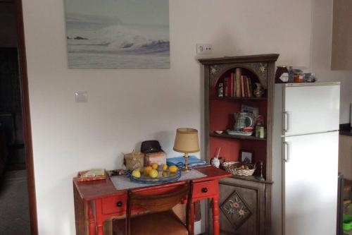 a table with a bowl of fruit on it next to a refrigerator at Casa Isabel 2 bedroom apartment near Porto in Fânzeres