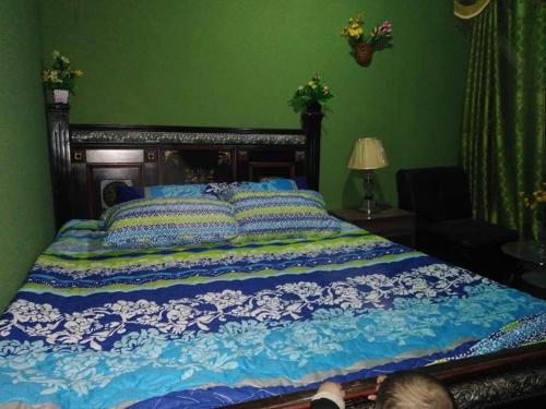 a bedroom with a large bed with blue and white sheets at High Cliff Guest House in Khaplu