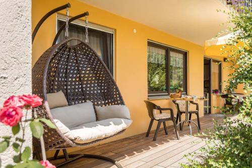 a hanging chair on a patio with a table at Bett und Frühstück bei Gertrud in Hergensweiler