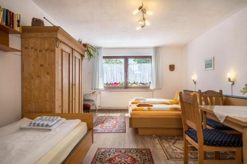 Habitación pequeña con 2 camas y mesa. en Bett und Frühstück bei Gertrud en Hergensweiler