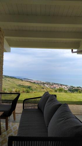 a couch on a porch with a view of a field at Casale Adriatico B&B in Pineto