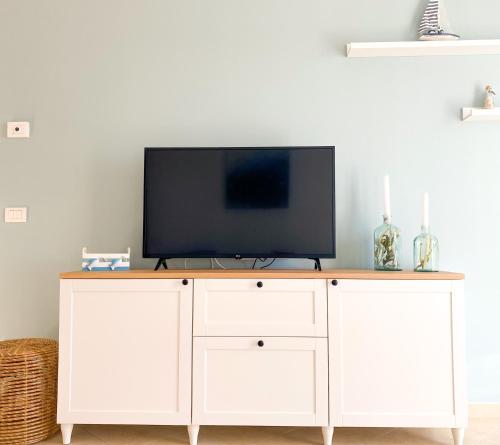 a white entertainment center with a flat screen tv on top at La perla del Porto in Porto Recanati