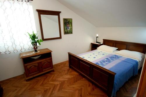 Schlafzimmer mit einem Bett und einem Wandspiegel in der Unterkunft Apartments Ivancevic in Korčula