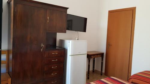 a kitchen with a white refrigerator and a wooden cabinet at Masseria Sciaiani Piccola in Villa Castelli