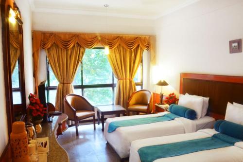 Habitación de hotel con 2 camas y ventana en Ashraya International Hotel, en Bangalore