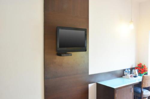 a television on the wall of a room at Ashraya International Hotel in Bengaluru