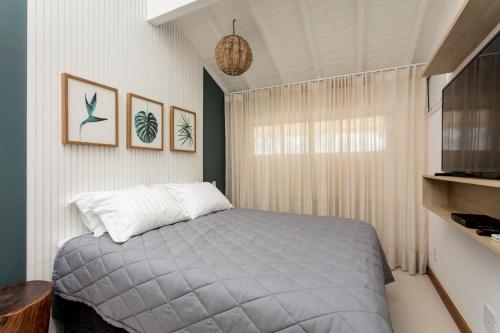 a bedroom with a bed and a window at Apartamento Luxuoso à Beira-mar em Praia do Forte in Praia do Forte
