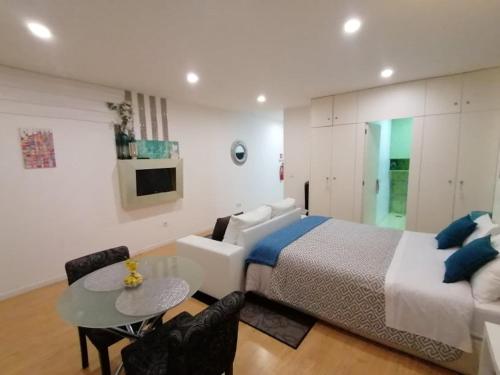 1 dormitorio con 1 cama, mesa y sillas en Be Happy in Porto en Oporto