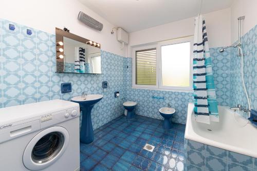 une salle de bains bleue pourvue d'un lave-linge. dans l'établissement Casa Oleander, à Crikvenica