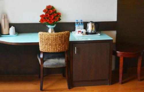 a table with a vase of flowers on top of it at Ashraya International Hotel in Bengaluru