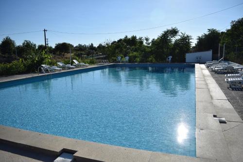 a large swimming pool with chairs in a resort at MemSoares Country House in Castelo de Vide