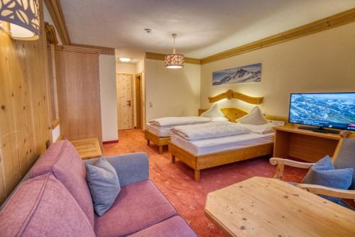 a hotel room with two beds and a couch at Gasthof Alt Paznaun in Ischgl
