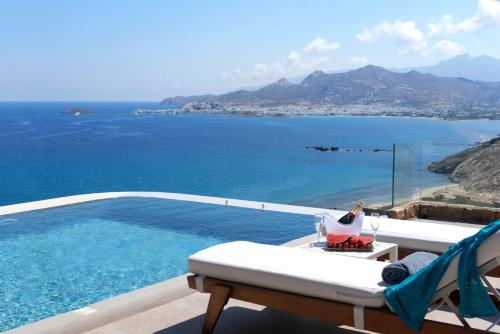 a view of a pool and the ocean from a balcony at Naxos Rock Villas in Stelida