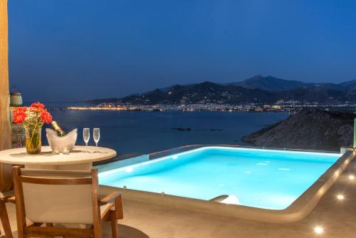a pool in a house with a view of the water at Naxos Rock Villas in Stelida