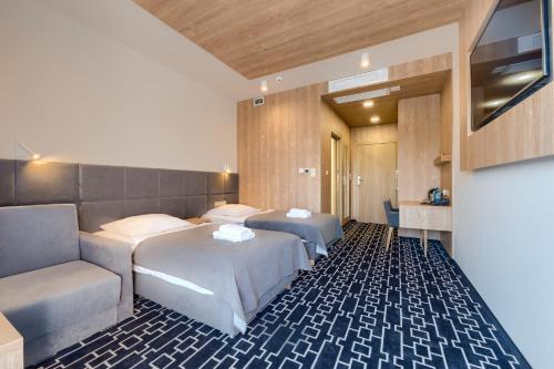 une chambre d'hôtel avec deux lits et un canapé dans l'établissement Hotel Wena, à Wrocław