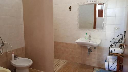 a bathroom with a sink and a toilet and a mirror at Masseria Sciaiani Piccola in Villa Castelli