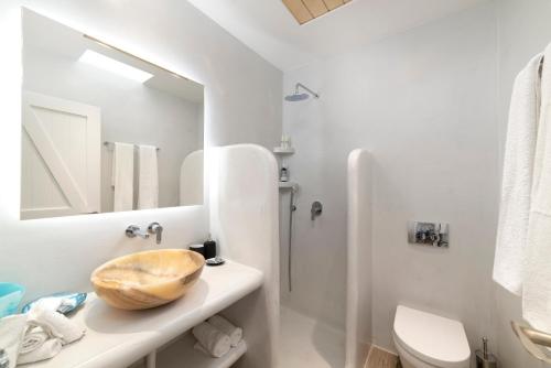 a bathroom with a sink and a toilet and a mirror at Naxos Rock Villas in Stelida