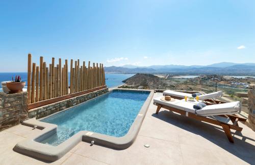 a swimming pool with a table and a bench on a patio at Naxos Rock Villas in Stelida