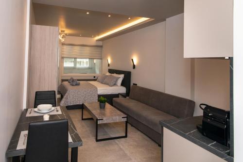 uma pequena sala de estar com um sofá e uma cama em Kastalia Living Thessaloniki em Tessalônica