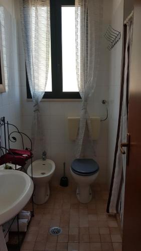 a bathroom with a toilet and a sink and a window at Masseria Sciaiani Piccola in Villa Castelli