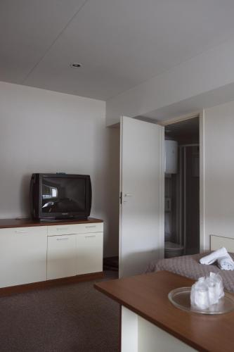 a hotel room with a tv and a bed at Motelis Gariūnai in Vilnius