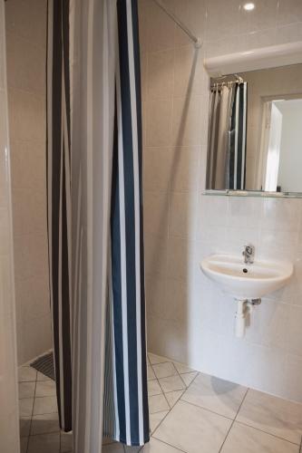 a bathroom with a sink and a shower curtain at Motelis Gariūnai in Vilnius