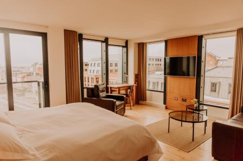 a hotel room with a bed and a tv and windows at Hope Street Hotel in Liverpool