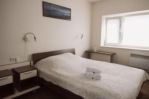 a bedroom with a bed with two towels on it at Motelis Gariūnai in Vilnius