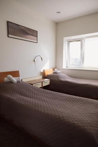 a hotel room with two beds and a window at Motelis Gariūnai in Vilnius