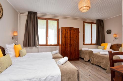 a bedroom with two beds and a table and chairs at H&ocirc;tel Les Essarts, USSIM Vacances in Valloire